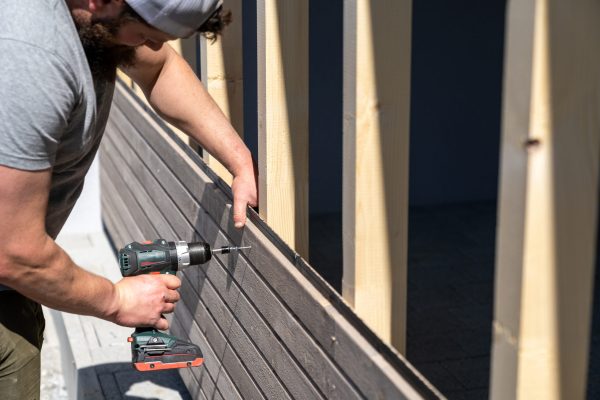 a-tough-construction-worker-applies-wooden-siding-2026-01-11-09-48-50-utc